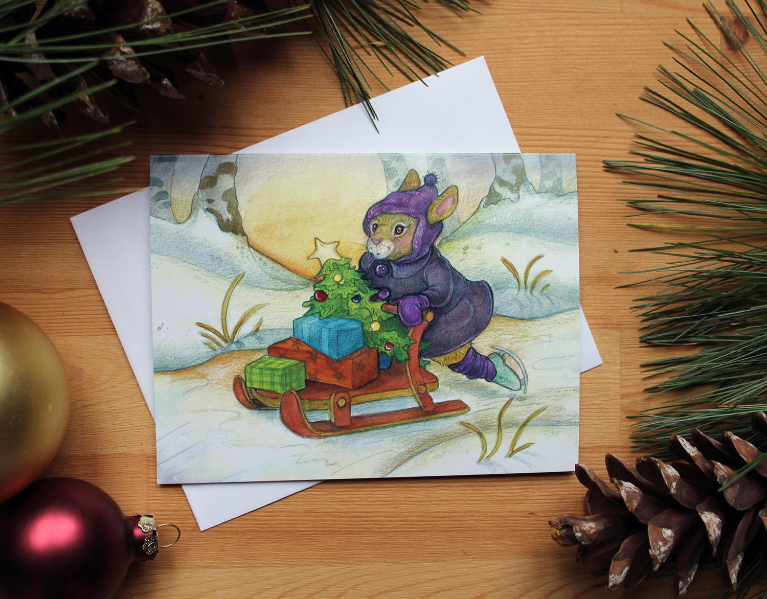 illustrated christmas card of bunny dressed in winter clothes and skates, skating home  on a creek, pushing a sled filled with gifts.