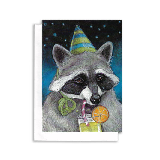 An illustrated  birthday greeting card showing a raccoon wearing a green and blue birthday hat and  drinking a green cocktail with an orange slice on the rim of the glass. 